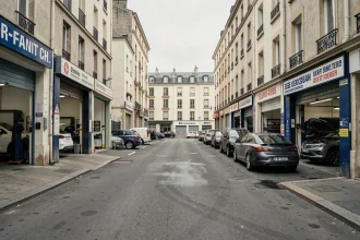 Vue de rue d'une zone de garages automobiles en Seine-Saint-Denis avec ateliers et véhicules garés
