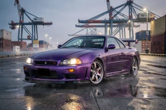 Nissan Skyline GTR R34 violet métallisé sur un quai de port japonais avec conteneurs maritimes en arrière-plan