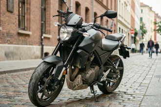Yamaha MT-125 garée en milieu urbain, vue trois quarts avant sur pavés, style naked bike compact et agressif
